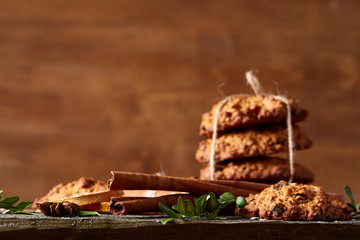 Christmas composition with oatmeal, chocolate biscuits, and spices, on wooden background, close-up, selective focus.
