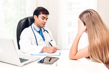 Doctor discussing and consulting with female patien on doctors table in hospital.healthcare and medicine
