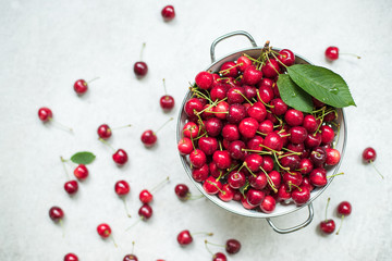Harvested Cherries in a colander topview on stone surface