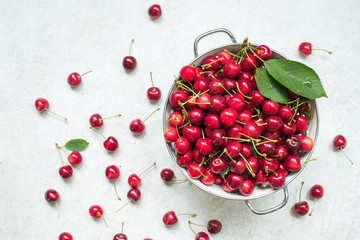 Harvested Cherries in a colander topview on marble surface