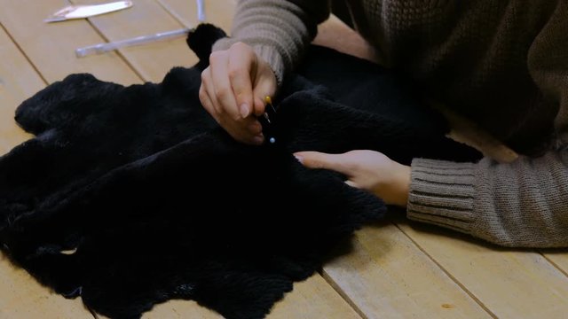 Professional male skinner, furrier working with beaver fur skin at atelier, workshop. Fashion and leatherwork concept