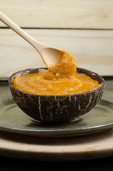 Healthy dessert made with avocado, chestnut and plum, served in a coconut shell