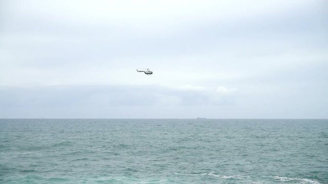 The helicopter in the sky. Slow motion.	The flying helicopter over the Atlantic Ocean.