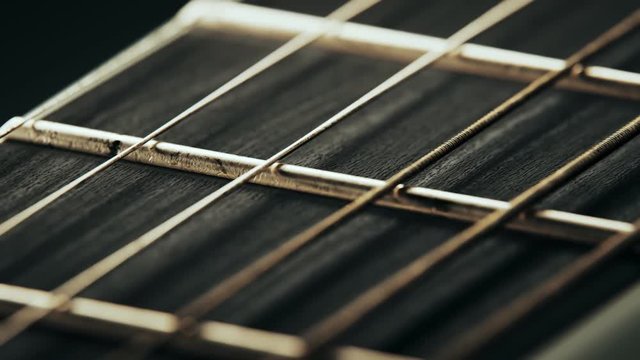 Fretboard details of six-string electric guitar. Worn out, rusty strings closeup