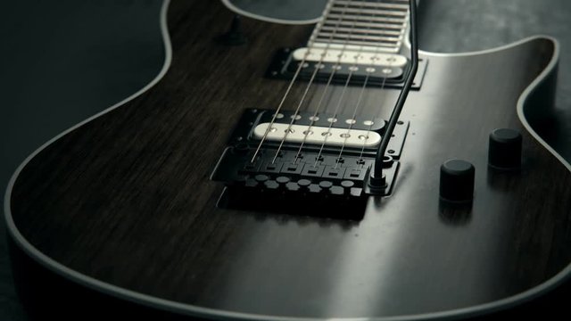 Details of six-string electric guitar. Pickups, strings, floyd-rose, fretboard.