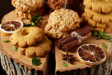 Conceptual composition with assortment of cookies and cinnamon on a wooden barrel, selective focus, close-up