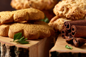 Conceptual composition with assortment of cookies and cinnamon on a wooden barrel, selective focus, close-up