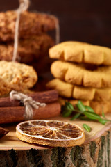 Fototapeta na wymiar Conceptual composition with assortment of cookies and cinnamon on a wooden barrel, selective focus, close-up