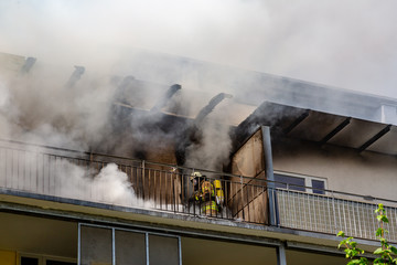 Fototapeta premium ein Feuerwehrmann versucht ein Wohnungsbrand in einem Hochhaus zu löschen
