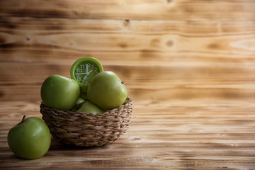 Green apples Put on a wooden table with measuring tape. And green clock Represents health care