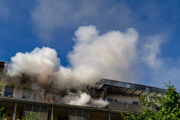 ein Wohnungsbrand in einem Hochhaus, viel Qualm auf dem Balkon