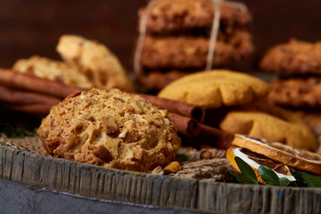 Conceptual festive composition with a cup of hot tea, cookies and spicies on a wooden barrel, selective focus, close-up