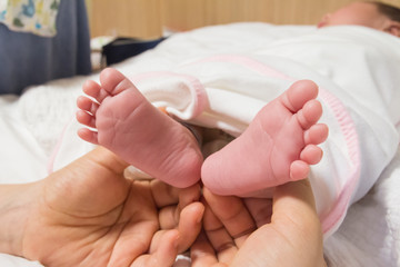 Obraz na płótnie Canvas new born baby foot on father's hand
