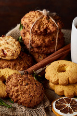 Conceptual composition with assortment of cookies and cinnamon on a wooden barrel, selective focus, close-up