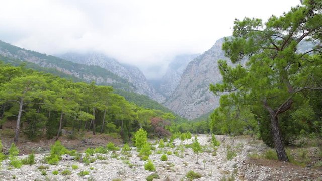 Beautiful cloudy scenic landscape. Dry stony bottom of river in forest. Taurus mountains in Turkey, Beldibi, between Kemer and Antalya turkish cities in distance.