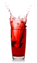 Splash of cherry juice in glass with an ice cube