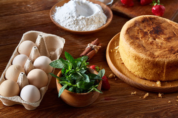 Delicious cake with fresh organic strawberries and kitchen utensils, top view, close-up, selctive focus.