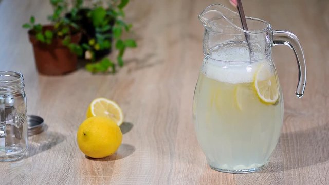 Glass of sparkling water soda drink lemonade with ice and lime lemon slice.