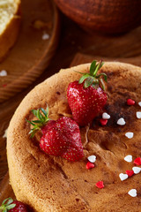 Baking background with strawberry tart covered with whipped sour cream, ingredients over wooden background.