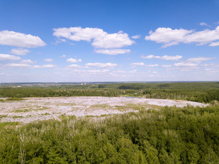 Fototapeta na wymiar Environmental pollution. Aerial top view photo from flying drone of large garbage pile. Garbage pile in trash dump or landfill near the green forest.
