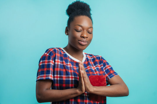 close up side view photo of African girl doing morning exercise. healthy life. free time. exercises for breast. meditating pose