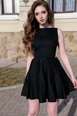 Fototapeta premium beautiful woman with dark hair in elegant dress walking on the street in summer city