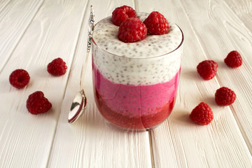 Pudding with chia and raspberries on the white wooden background
