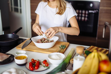 Home cozy kitchen chef female making pickled turkey meat with rosemary leaves. Barbecue concept or healthy meat lifestyle shot