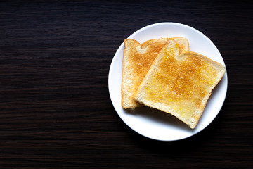 Bread with orange jam on black wood table in the morning.
