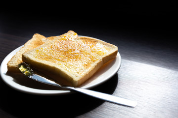 Bread with orange jam on black wood table in the morning.