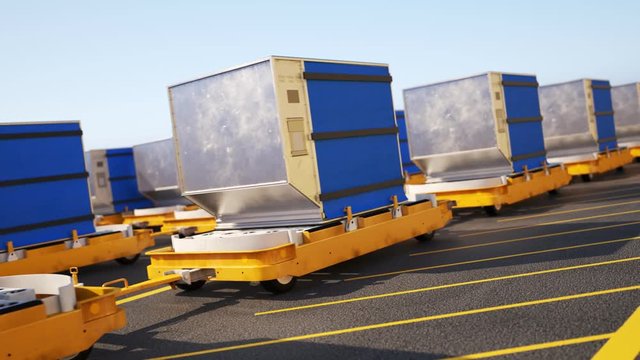 Blue cargo containers on yellow flatbed dollies in an industrial yard
