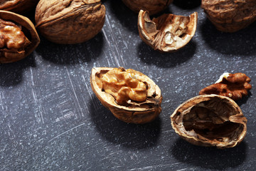 Walnut kernels and whole walnuts on rustic old table