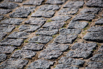 Old square stone pavement is close up