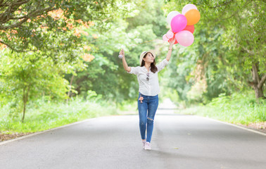Fototapeta na wymiar Young hipster girl holding balloon walk on the road,