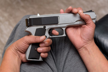 Woman holding a gun on her lap