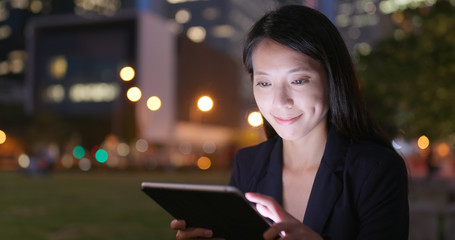Businesswoman working on notebook in city at night
