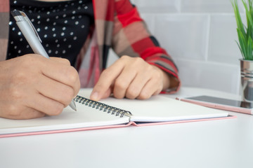 Businesswomen and personal thoughts Write a note on a white desk.
