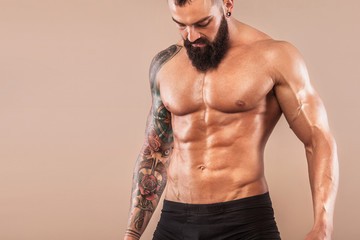 Muscular young fitness sports man with strong fit body on light background.