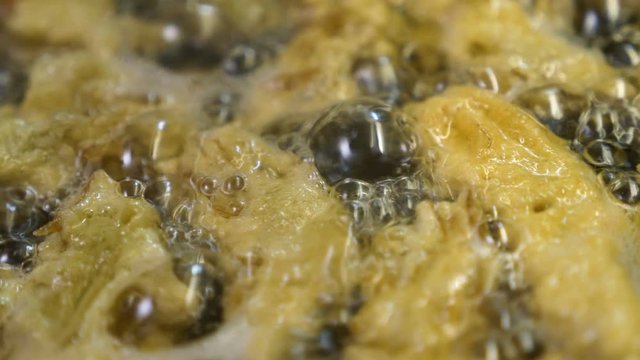 frying tasty artichokes in boiling olive oil - macro