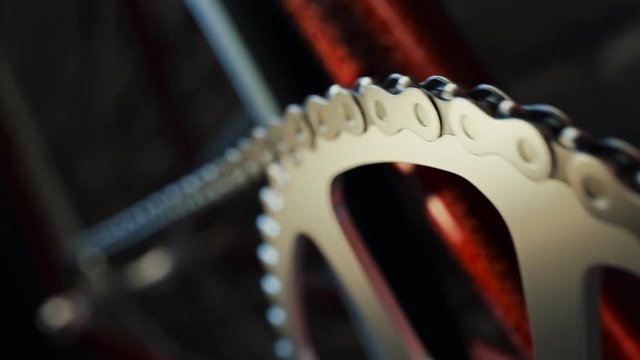 Bicycle over a black background. Loopable shot of spinning chain and chainring.