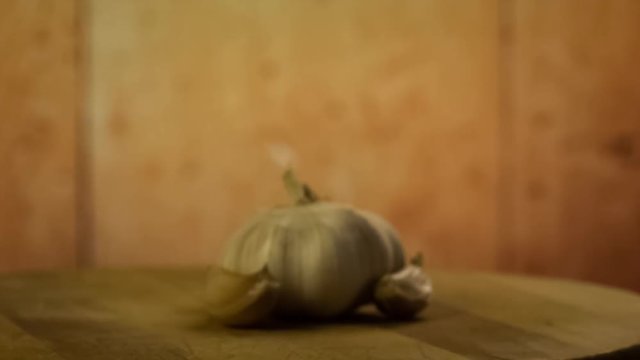 Head of garlic and cloves of garlic on wooden desk. Still life. Rotating, turntable shot. Racking focus