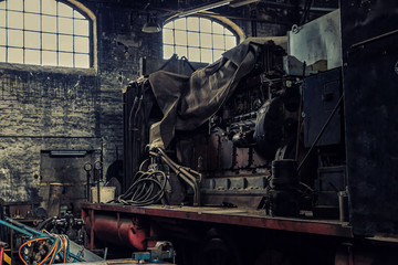 The open engine of an old electric locomotive in an abandoned workshop