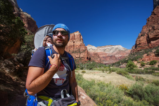 A man with his baby boy are trekking in Zion national park, Utah, USA