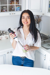 Attractive woman making smoothie indoors