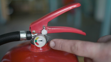finger shows what pressure should be in the fire extinguisher, c