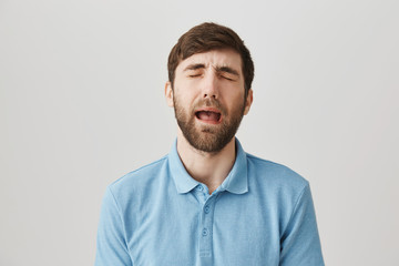 Obraz premium Waist-up shot of upset handsome caucasian guy in shirt, whining or crying as if he is baby, standing over gray background. Wife put password on laptop so he can not play game until he finish laundry