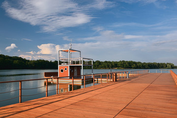 Obraz premium New wooden molo with small tower on Kamencove jezero alum lake in czech city of Chomutov at evening after rain in June 2018
