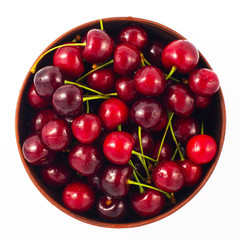 Fresh cherry in a bowl isolated on white background. Top view