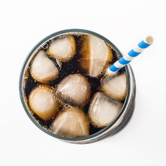 Cola in glass with straw and ice cubes isolated on white background. Top view