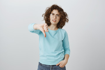 Girl displeased with bad idea. Indoor shot of annoyed displeased young woman with curly hair in...